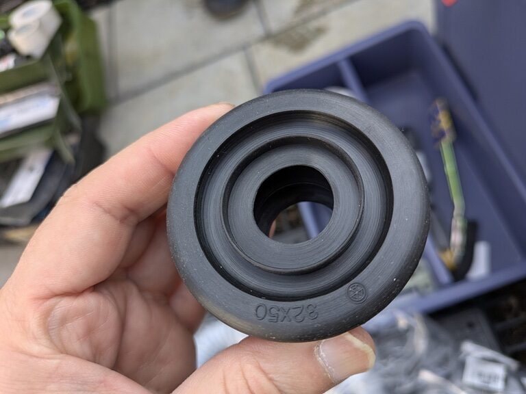 実際に使用しているキッチン下の防臭ゴムの写真。50mmの配管にキャップのようにはめ込み、蛇腹のホースを差し込んで使用しています。